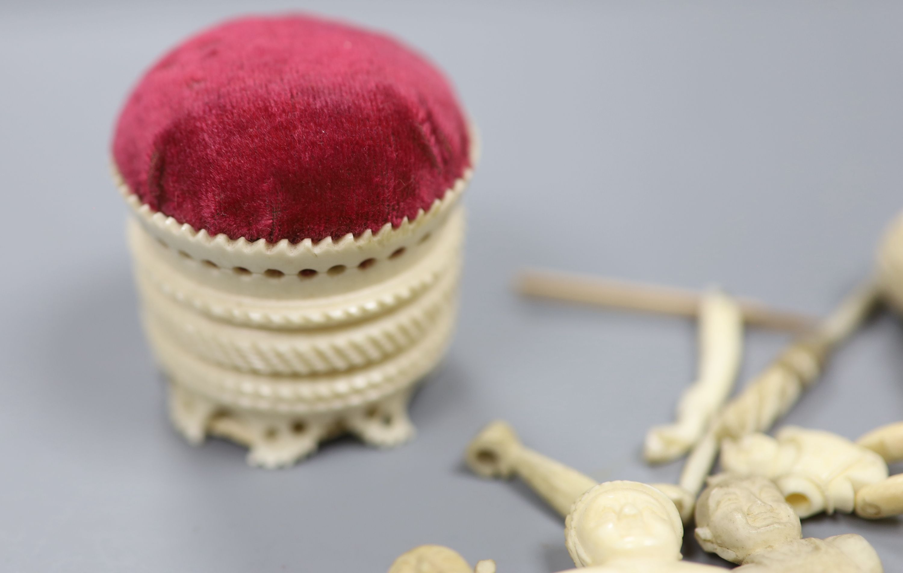 Three Chinese articulated ivory models of acrobats, two chess pieces, an ivory brush handle and needlework items